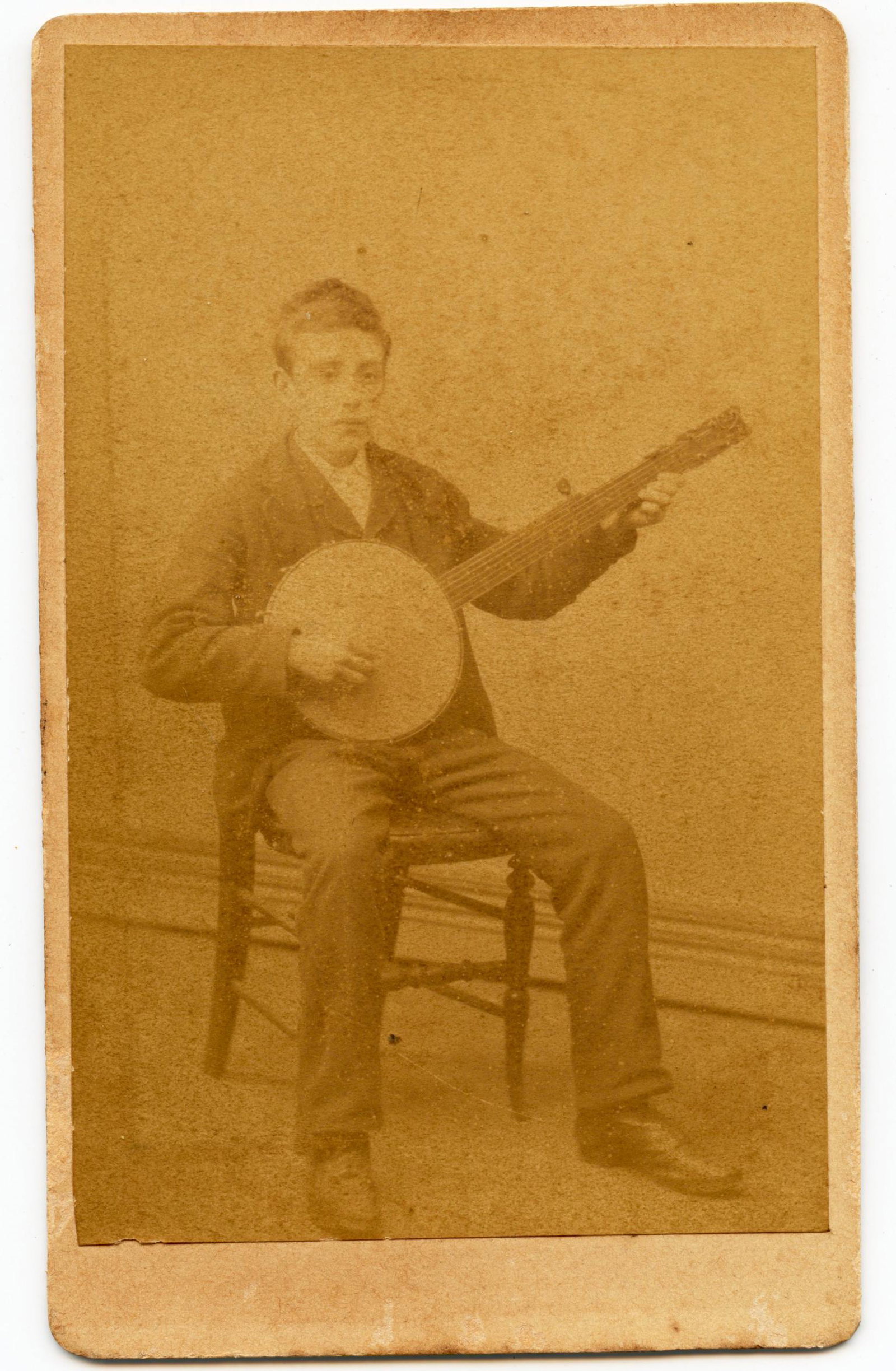 CDV Studio Pose: CDV Studio Pose Studio pose of a young man sitting in a chair playing the Banjo