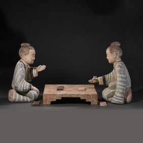 A pair of painted pottery figurines of people playing chess, dating back to the Ming Dynasty or