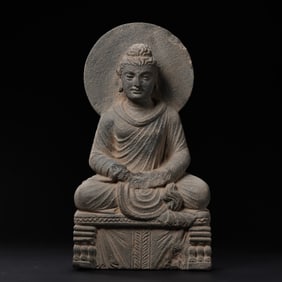 A 2nd century Gandhara bluestone statue of a seated Buddha