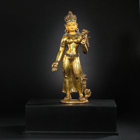A Chinese gilt-bronze and gem-inlaid standing Buddha statue from the Yuan Dynasty