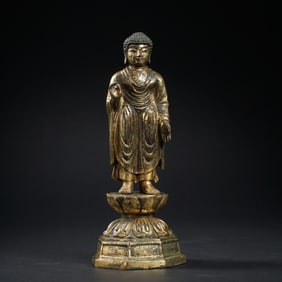 A CHINESE MING DYNASTY GILDED BRONZE STATUE OF STANDING SAKYAMUNI BUDDHA