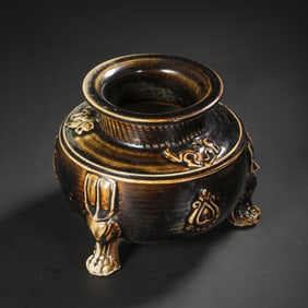 BLACK-GLAZED TRIPOD STOVE WITH PLASTIC DECORATION FROM GONGXIAN KILN, TANG DYNASTY, CHINA
