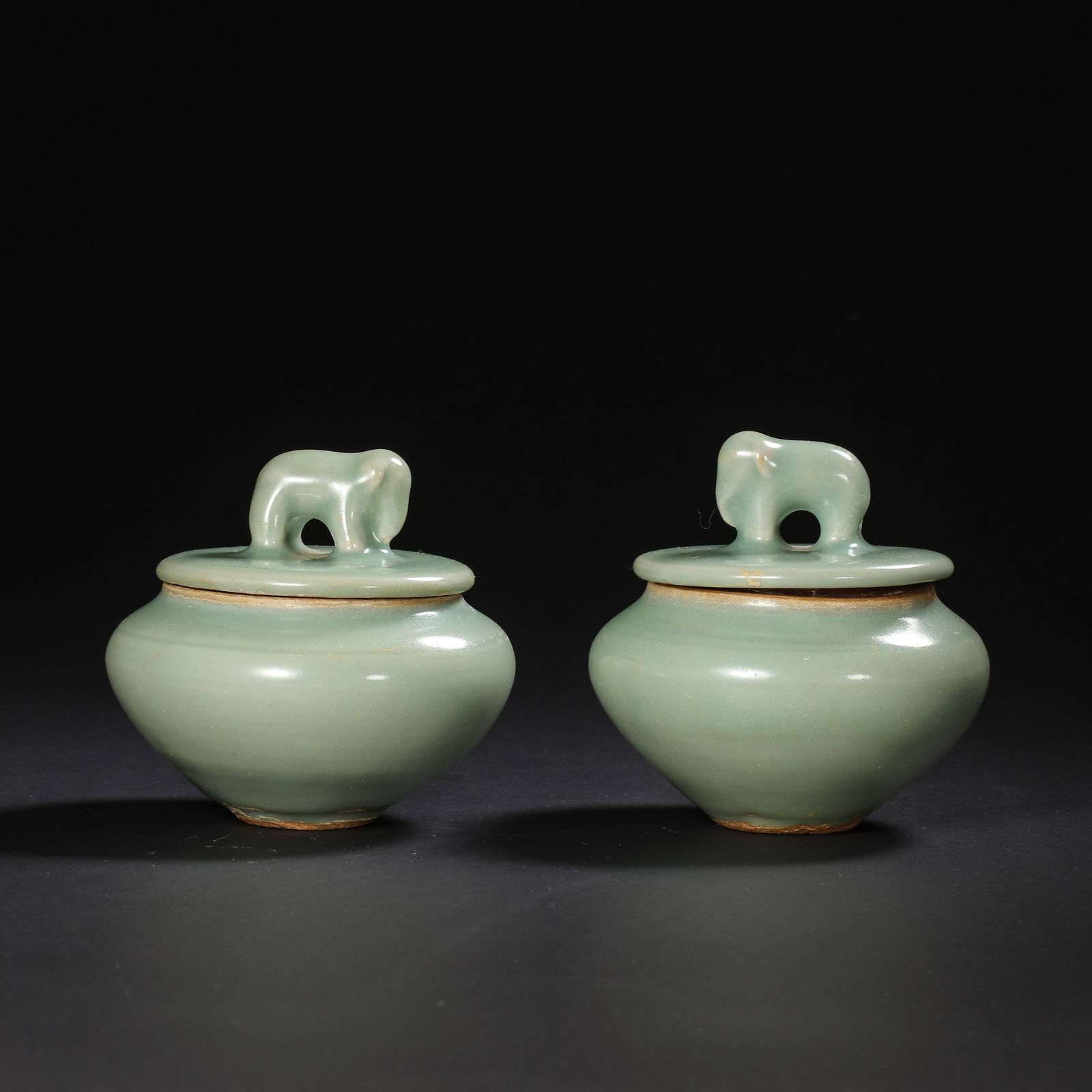 A PAIR OF CHINESE SOUTHERN SONG DYNASTY LONGQUAN KILN GREEN GLAZE ELEPHANT-SHAPED LIDDED JARS: H . 8.5 cm . L . 8.5 cm . H . 9 cm .