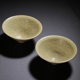 A pair of Yaozhou kiln green-glazed bowls with coiled flower and sea fish designs from the Northern