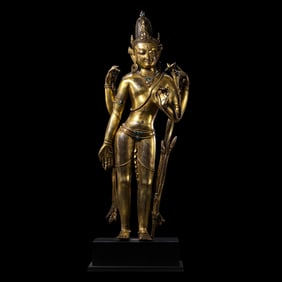 A 15th-century Chinese gilt-bronze statue of a standing Buddha in the Mala style