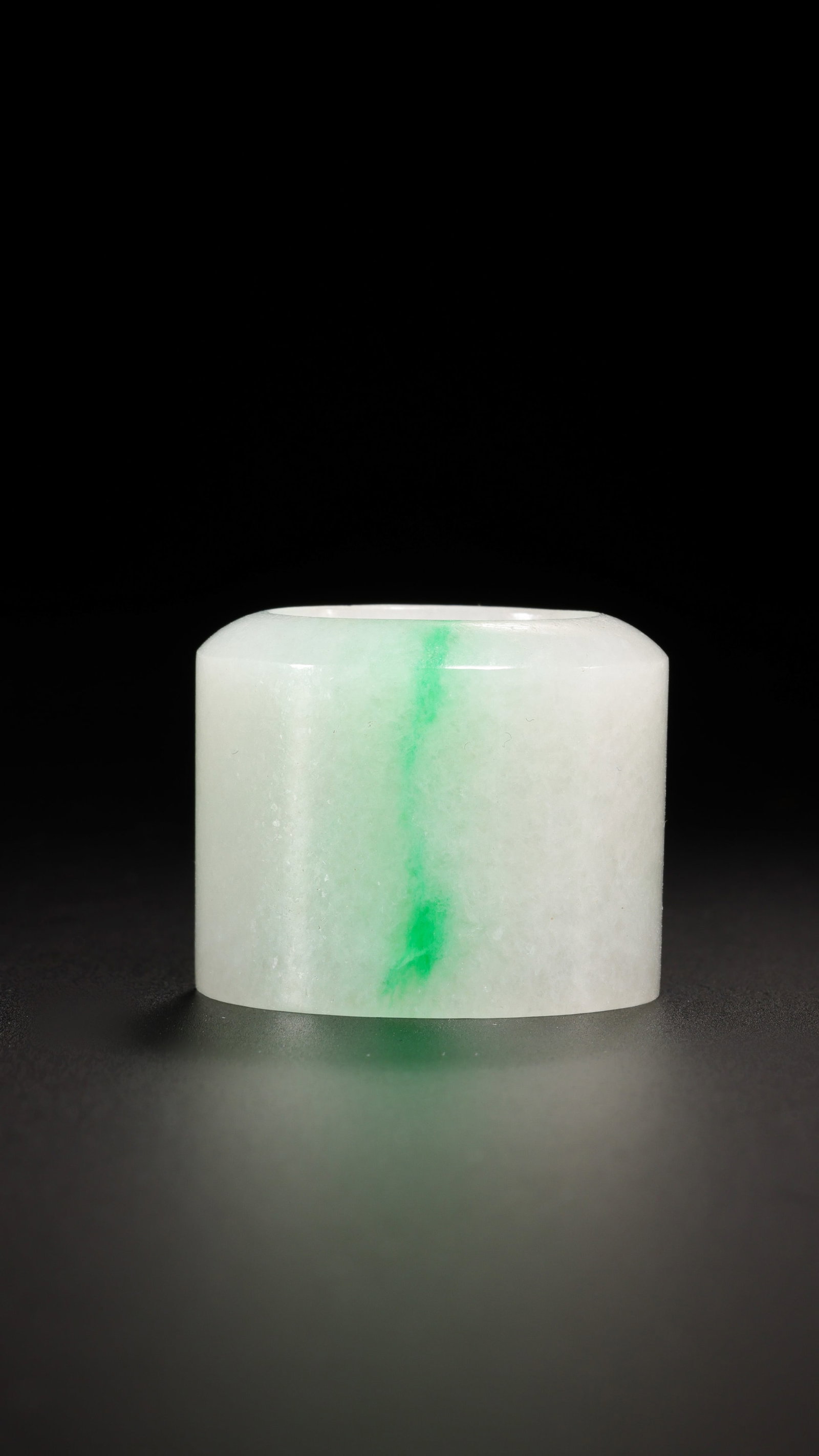 A Chinese Qing Dynasty Plain Jadeite Archer’s Ring: Height: 2.5 cm; Width: 3 cm; Weight: 34 gCondition and Provenance?In good overall condition. The ring is of cylindrical form with smoothly rounded rims and an unadorned exterior. The stone is primaril