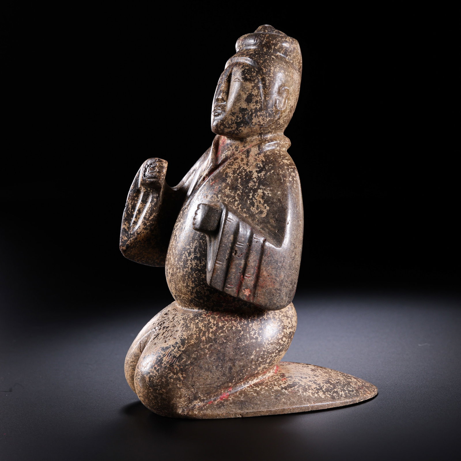 A Chinese Warring States Hetian Jade Kneeling Figure: 5th–3rd century BCE; Height: 8.7 cm; Width: 6.5 cm; Weight: 202 gCondition and Provenance?In good overall condition. The figure is carved in the round from Hetian jade and shows deep celadon-brown t