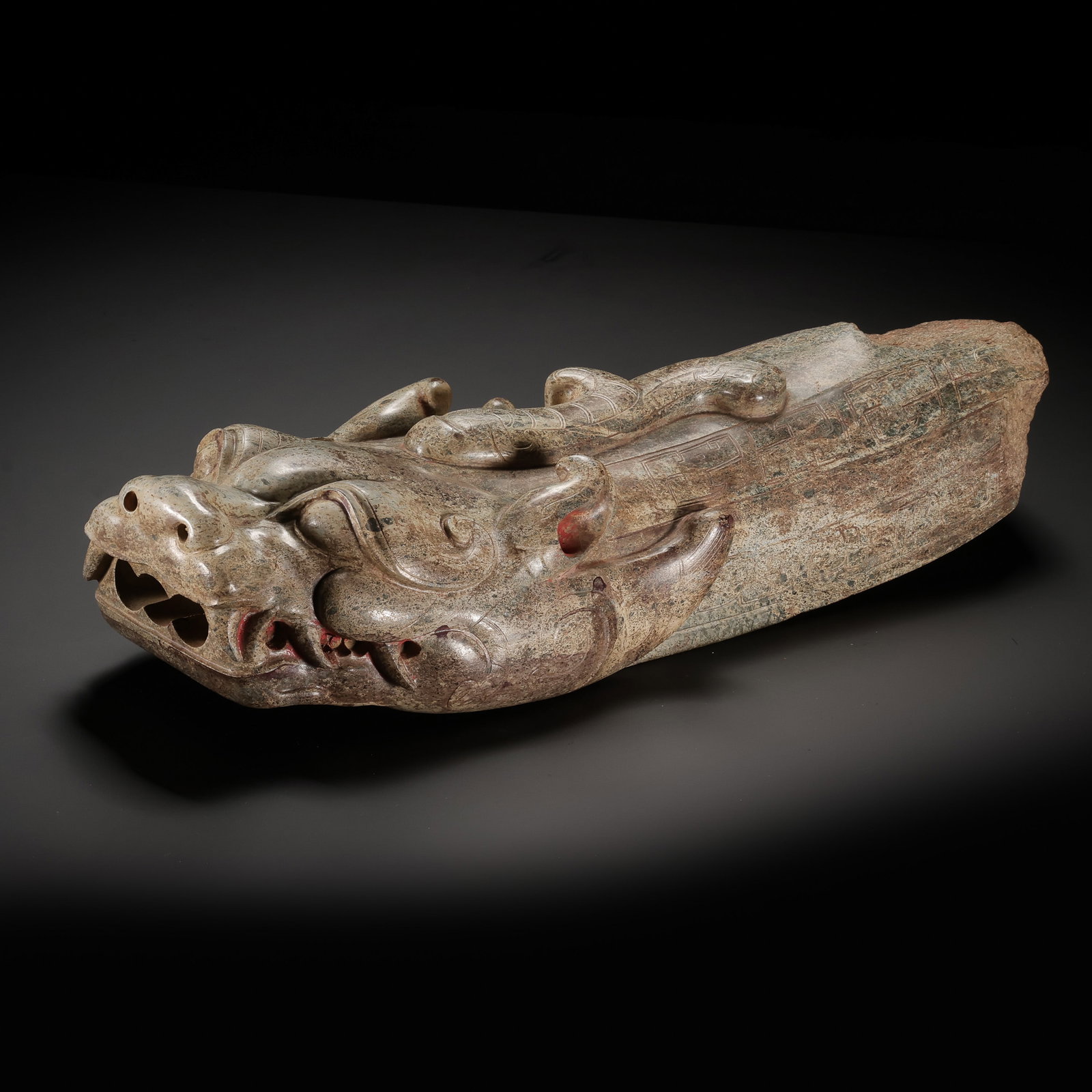 Chinese Warring States Hetian Jade Dragon-Head Form Object: 5th–3rd century BCE; Length: 39 cm; Height: 8 cm; Weight: 6683 gCondition and Provenance?In good overall condition. The object is carved from a massive block of Hetian jade and displays grayish cela