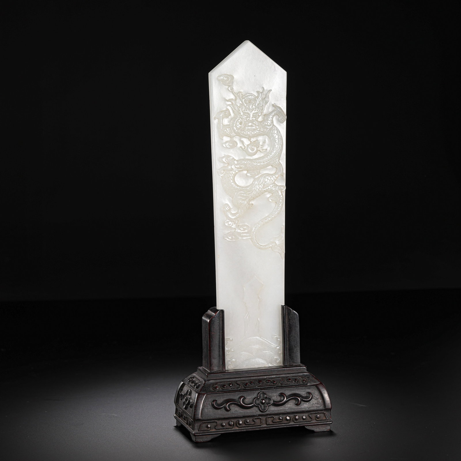 Ming Dynasty Hetian Jade Archaistic Tablet-Form Plaque with Carved Dragon (Mounted Display): 14th–17th Century; H. 21 cm, W. 5 cm; Weight 340 g; H. approx. 8.27 in, W. approx. 1.97 inCondition and Provenance: Good condition, with the form intact, fine and smooth jade texture, well-polished 