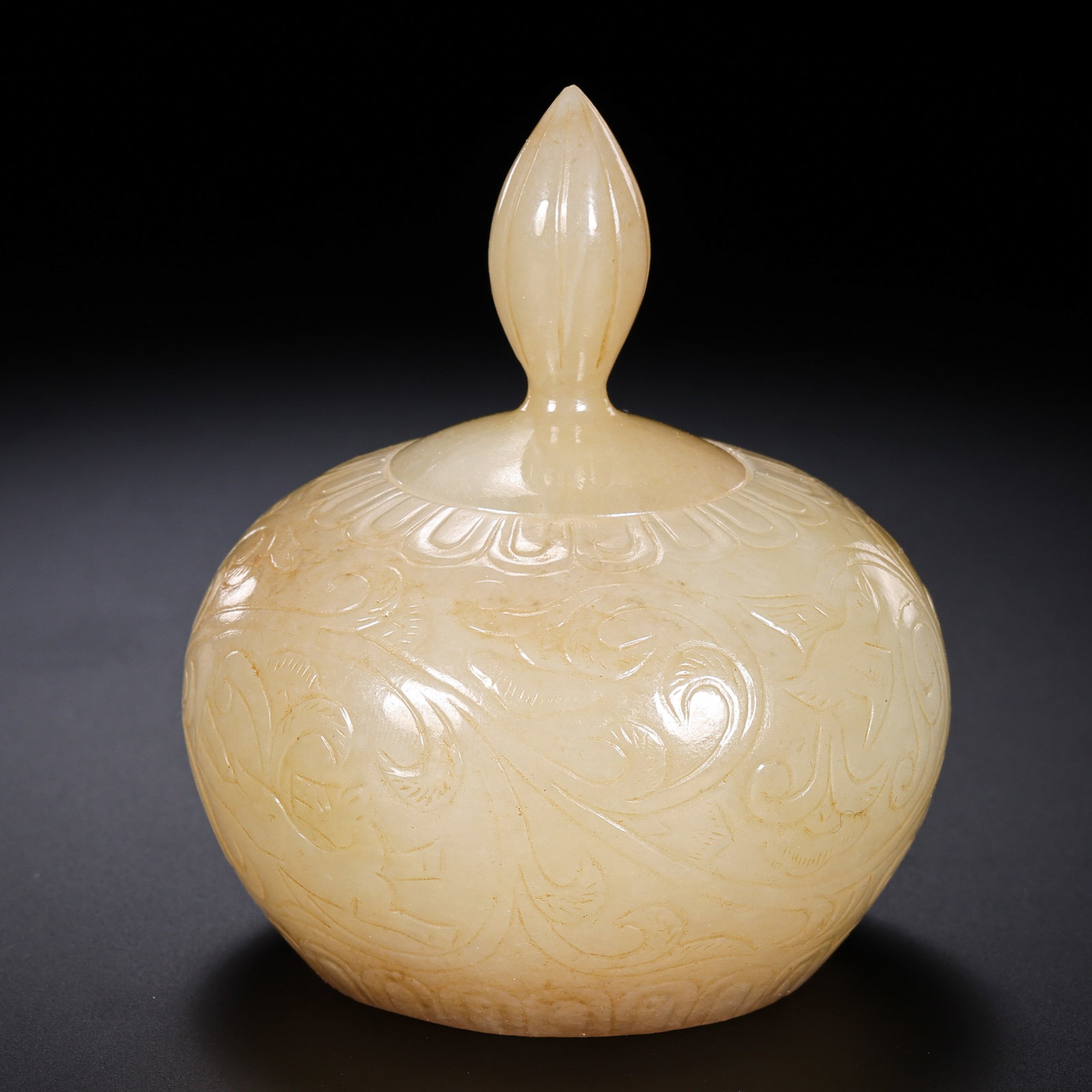 Tang Dynasty Hetian Jade Covered Box with Low-Relief Scroll Design: 7th–10th Century; H. 7 cm; Weight 75 g; H. approx. 2.76 inCondition and Provenance: Good condition, with the overall form intact, smooth polish, warm jade texture, minor natural coloration, veining,
