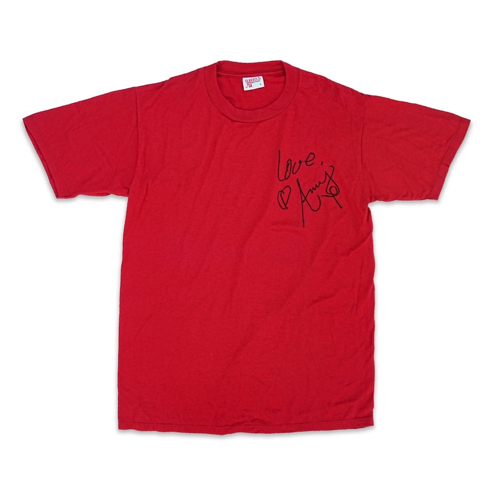 AMY WINEHOUSE SIGNED 1990s SUNBELT AMERICAN-MADE RED T-SHIRT: Size L; Length: 28 in (71 cm); Shoulder: 18 1/8 in (46 cm) Provenance and Authentication: According to the accompanying documentation provided by the consignor, the signatures have been examined with