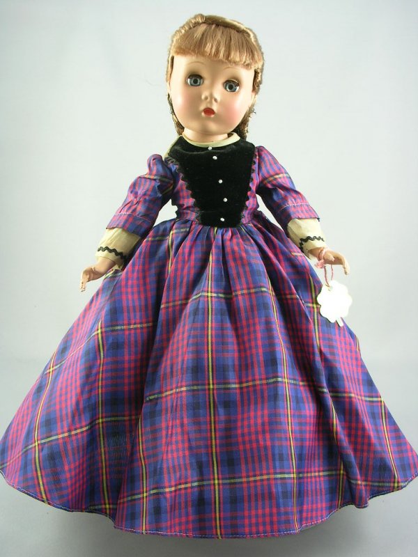 14" LITTLE WOMEN "JO" BY ALEXANDER: Five-piece hard plastic body, Maggie face, sleep eyes, light brown floss wig, tagged taffeta dress. Includes clover wrist tag. Circa 1948, #1500.