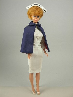 Bubble Cut Barbie wearing "Registered Nurse": Blonde hair, blue eyes, red lips, straight legs, wearing white nurse's uniform, blue with red lining cape, white nurse cap, white "Japan" marked open toe shoes (both left and split). All accessories a