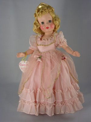 16" HARD PLASTIC HONEY CINDERELLA BY EFFANBEE: Hard plastic five-piece body, blonde mohair wig in beautiful original set. Wearing original pink ball gown with netting and gold braid trim, matching undergarments, gold tiara and clear vinyl slippers