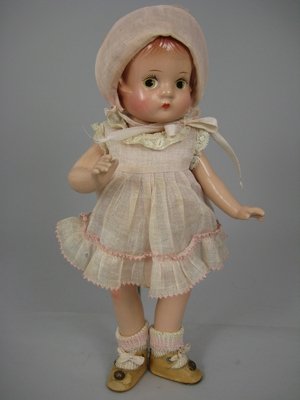 9 1/2" COMPOSITION EFFANBEE PATSYETTE: Marks: Effanbee//Patsyette//Doll on back. Five-piece body, painted eyes, molded and painted hair. Wearing original pink dress with attached onesie. Minor crazing on body. Early 1930s.