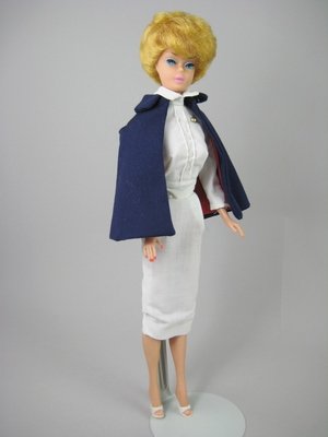 BUBBLECUT BARBIE WEARING "REGISTERED NURSE": Straight legs, golden blonde hair, blue eyes, pierced ears, pink lips. Wearing white nurse uniform and cap, navy blue cape with red lining, and white "Japan" marked open toe shoes. COMPLETE with medic