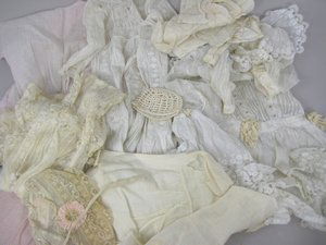 BOX OF ASSORTED ANTIQUE DOLL CLOTHES: Collection contains many smaller cotton slips, assorted dresses, play clothes, smaller bonnets, one small tagged Effanbee romper.