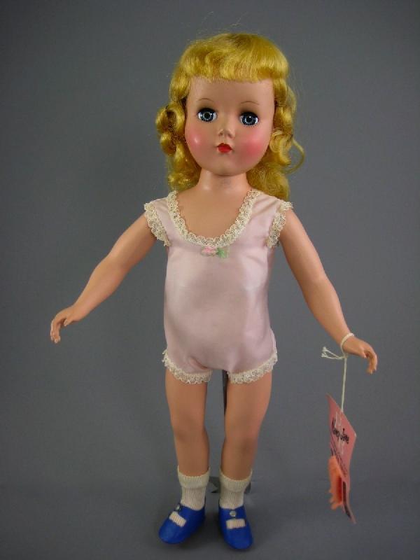 17" HARD PLASTIC DOLL BY ARRANBEE WITH CURLERS: Marked "R&B" on back of head. Blonde saran hair in original set, gray sleep eyes with all lashes, closed mouth, five piece strung body, original pink nylon chemise, nylon socks and blue one snap shoes