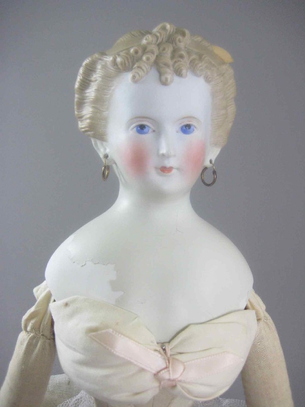 27" FANCY PARIAN DOLL: Head is 6"H. Light brown hair has fancy curls with two molded bands and a chignon in back, pierced ears and nicely painted features. Sawdust stuffed body with new limbs, partially dressed. Head is rep