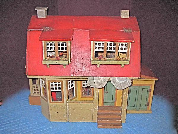 GOTTSCHALK DOLLHOUSE WITH SIDE PORCH & GARAGE: Unmarked. 22"W x 17"H x 10"D. This desirable house has a bay window with interior seat and lace curtains, side porch with lattice trim and working door plus a two door garage complete with an old cast