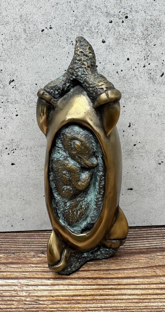 Bob Wilfong Baby Emperor Penguin in Egg Bronze: 5 1/2" by 2" by 1 7/8". Bob Wilfong (late 20th century) was active/lived in Washington. Bob Wilfong is known for Abstract figure sculpture. Bob Wilfong began his sculpting career in 1993 when he could