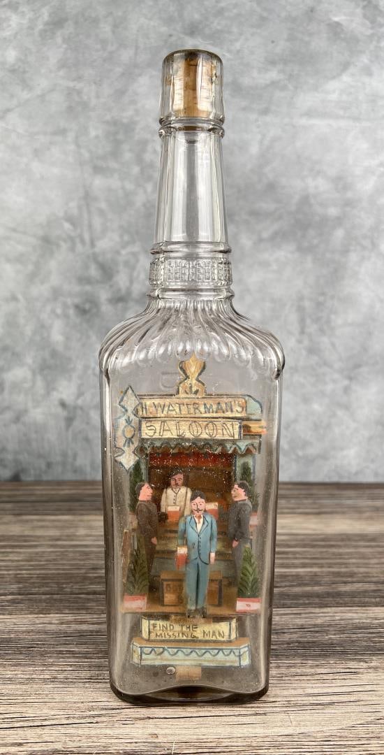 Carl Worner Folk Art Saloon Bottle Whimsy: Title is Find The Missing Man, H. Waterman's Saloon. 11 3/4" tall. Carl Worner (20th Century) is known for Painting. Carl Worner is regarded as one of the best known folk art bottle builders by collec