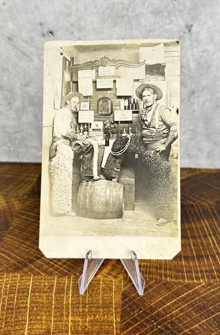 Armed Montana Cowboys RPPC Photo Postcard: Wearing wooly chaps and wild rags, the cowboy on the left is brandishing a pistol. 5 1/2" by 3 1/2".
