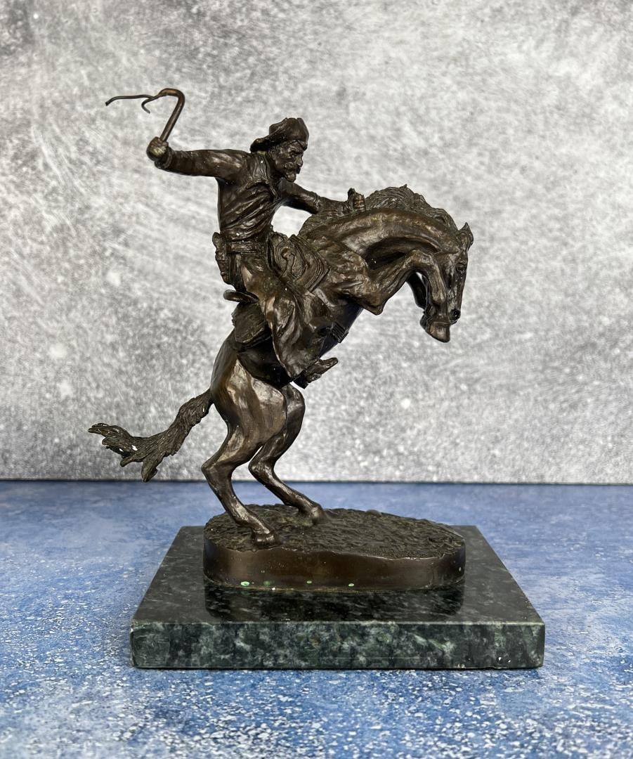 Frederic Remington The Bronco Buster Bronze: Title is The Bronco Buster. 7 7/8" by 6 3/4" by 4 1/4". In his lifetime polymath Frederic Remington was the most successful and famous Western American artist. His immense talents included excelling a