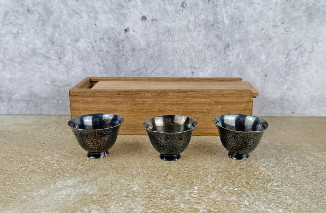Chinese Sterling Silver Hammered Finish Sake Cups: Three total in wood case. Presentation writing on the side. 1 1/4" tall by 1 3/4" in diameter. 73.19 grams.