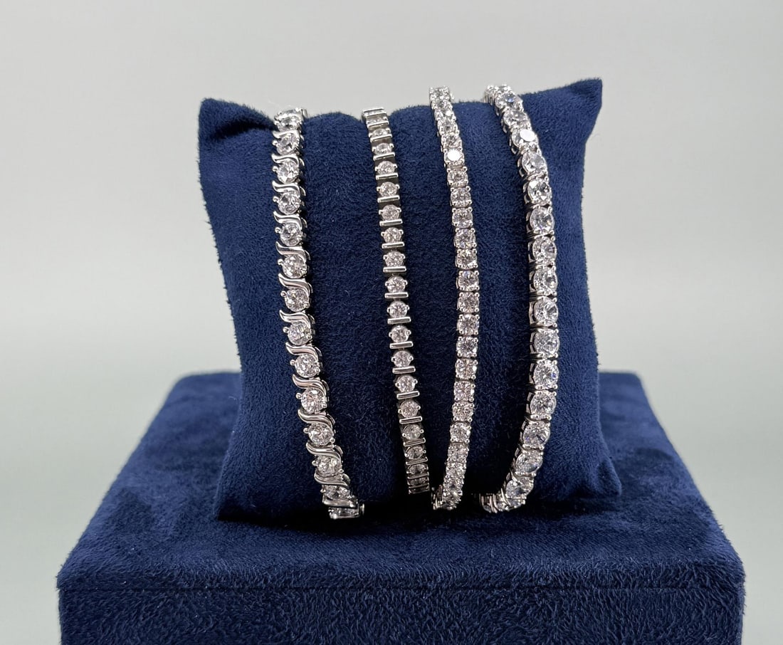 Group Of Sterling Silver CZ Tennis Bracelets: Four total. Longest is 8" long open. 60.87 grams combined weight.