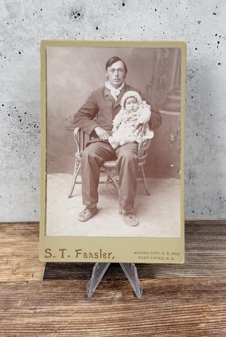 Fort Yates Indian Family Cabinet Photo: John Foster and Baby. 4 1/4" by 6 1/2". Provenance: The Estate of George W Reed Indian Missionary and Pastor of Standing Rock Reservation Fort Yates North Dakota.
