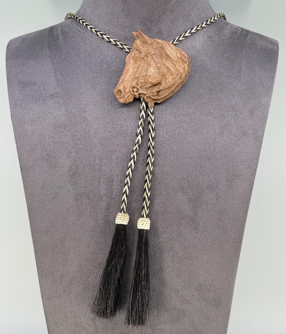 Harold Holden 2011 Prix de West Bronze Bolo Tie: Title is The Snaffle. 21" long on bolo tie. Harold T. Holden (1940 - 2023) was active/lived in Oklahoma. Harold Holden is known for Cowboy figure and animal sculptor.