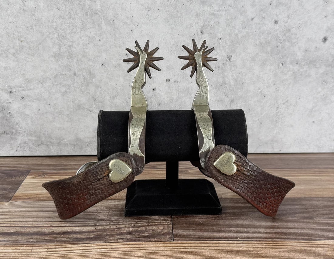Buermann Silver Overlay Ladies Leg Cowboy Spurs: Superb set of spurs. Rare #2047 Double Ladies Leg pattern. Untouched patina and original condition. 8" long with strap. As good as they get. Provenance: Collection of Netty and Ted McIntyre