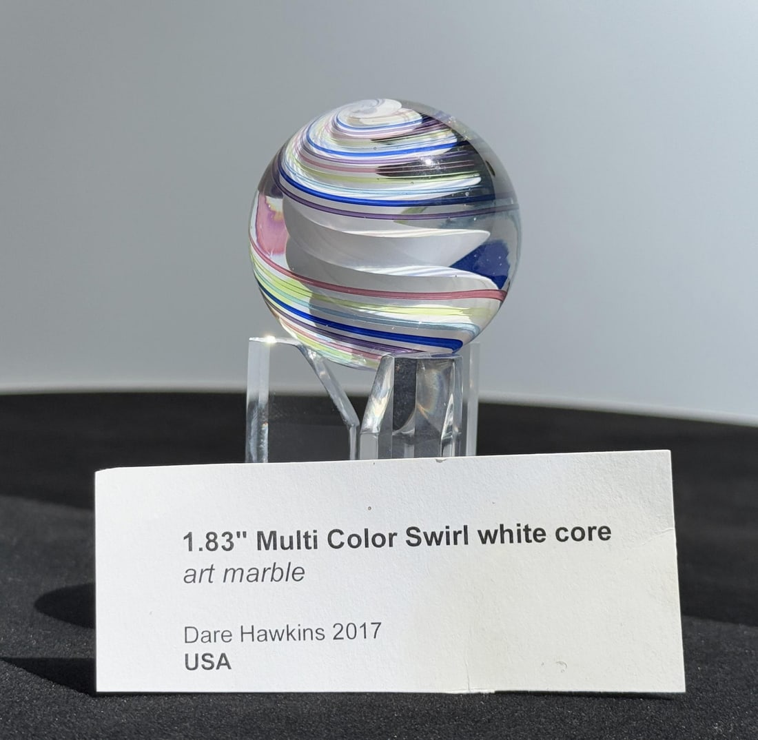 Dare Hawkins White Core Swirl Art Glass Marble: 1 7/8" diameter. Dare Hawkins is a modern handmade glass marble artist based in West Virginia, originally from Virginia. He began crafting his distinct swirl-patterned marbles many in the 1 to 2" size