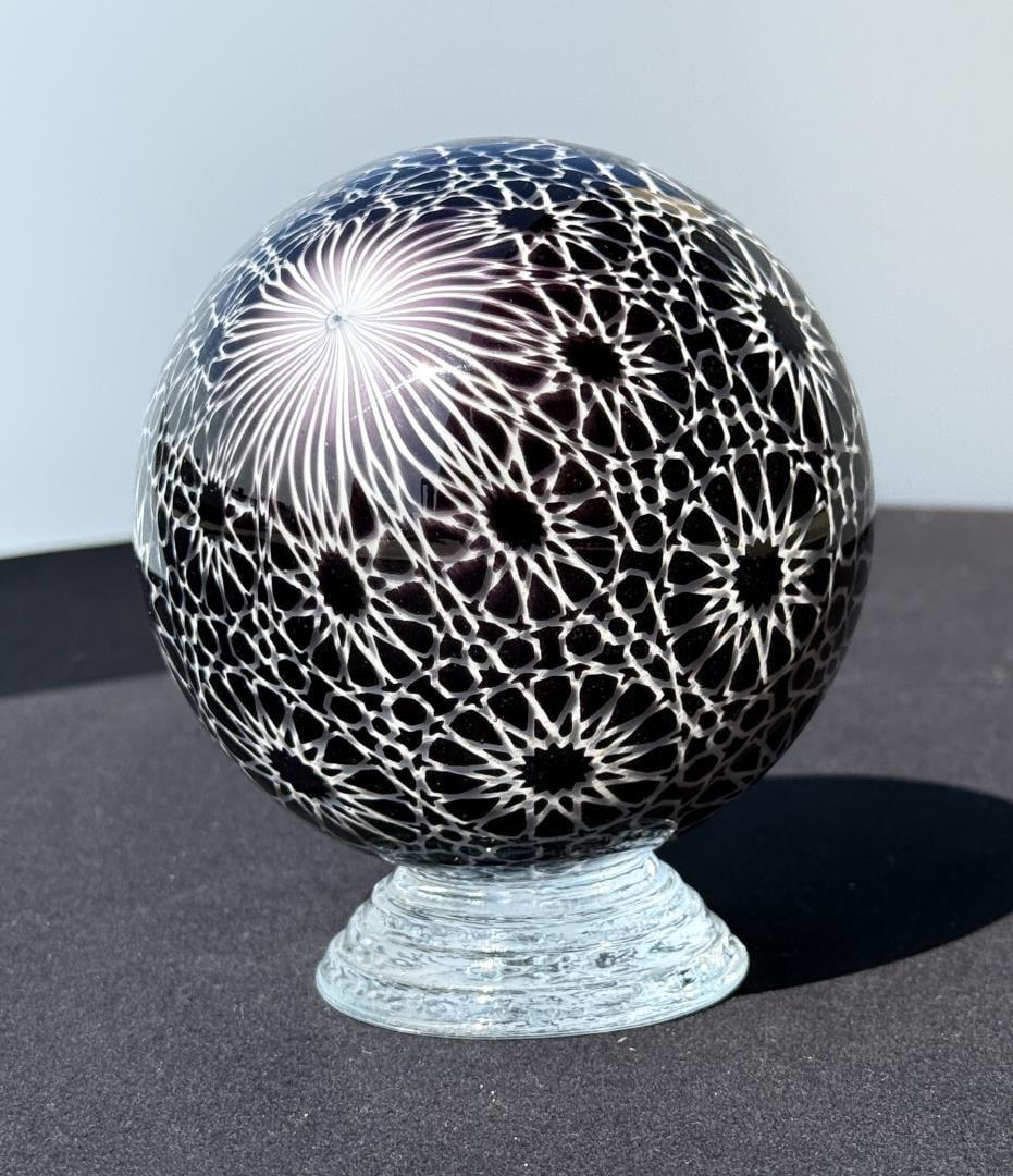 Mark Matthews White Arabesque Jumbo Marble: 4" diameter. Signed and dated Matthews 2013. Black and White Graal Sphere. Mark Matthews is notably recognized for his work in glass, especially in glass spheres. Working with only one assistant, each