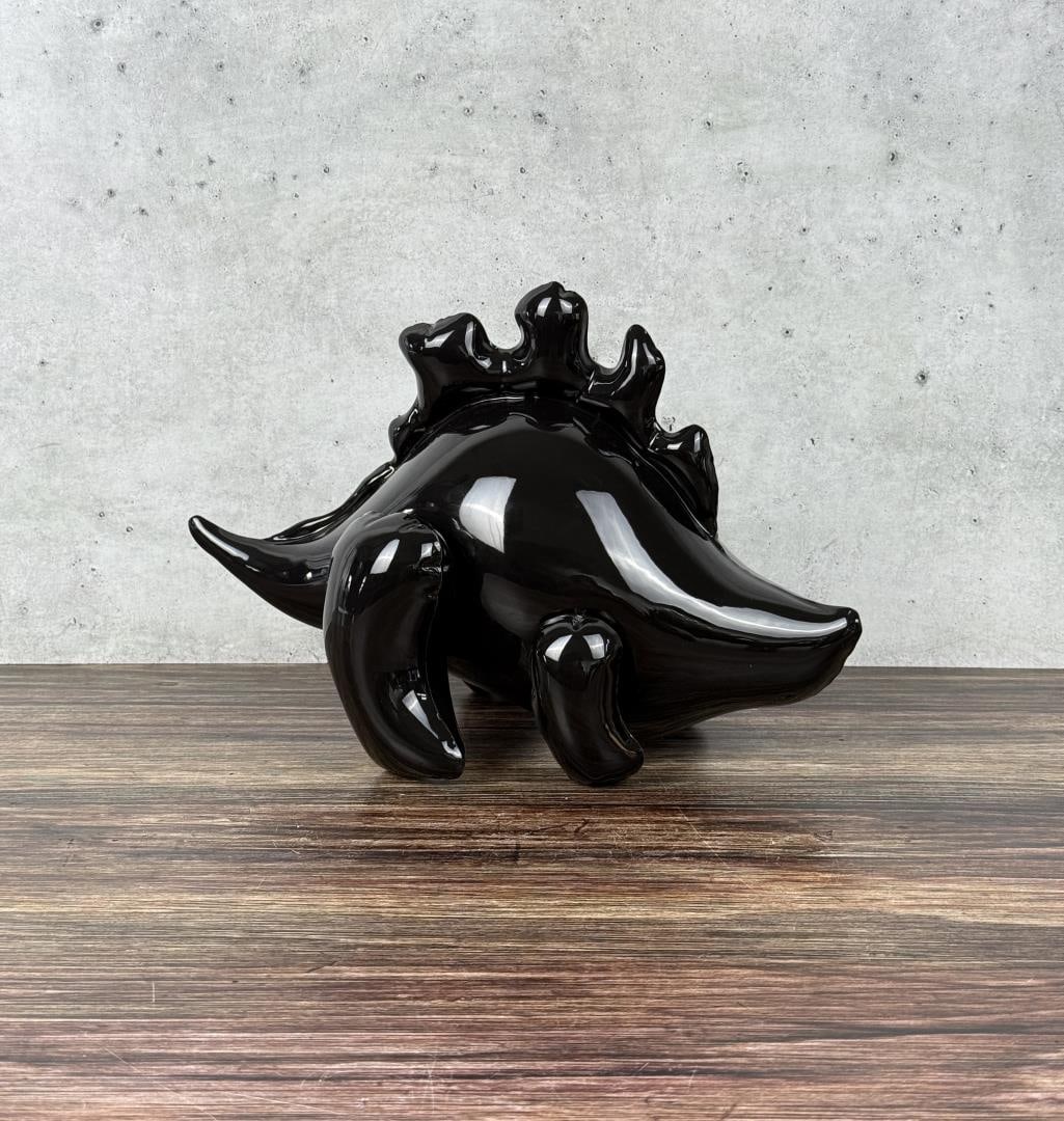 Brett Kern Inflatable Pottery Stegosaurus Dinosaur: 10" long, 8 1/4" tall, 7 3/4" wide. Although it looks inflatable and soft, the dinosaur is ceramic. Plug is ceramic with gold luster. Brett Kern (20th Century) is known for Sculpture.