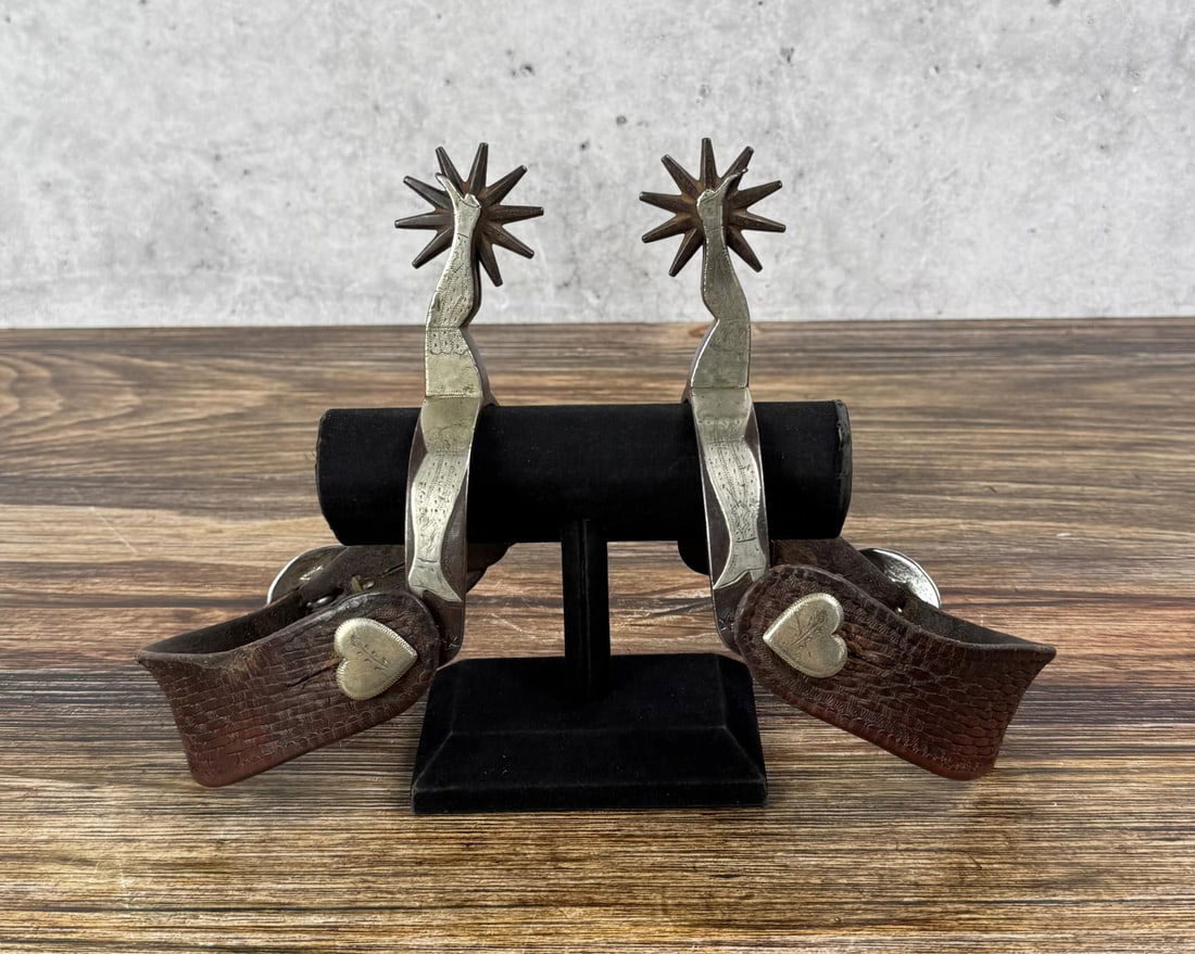 Buermann Silver Overlay Ladies Leg Cowboy Spurs: Superb set of spurs. Rare #2047 Double Ladies Leg pattern. Untouched patina and original condition. 8" long with strap. As good as they get. Provenance: Collection of Netty and Ted McIntyre.