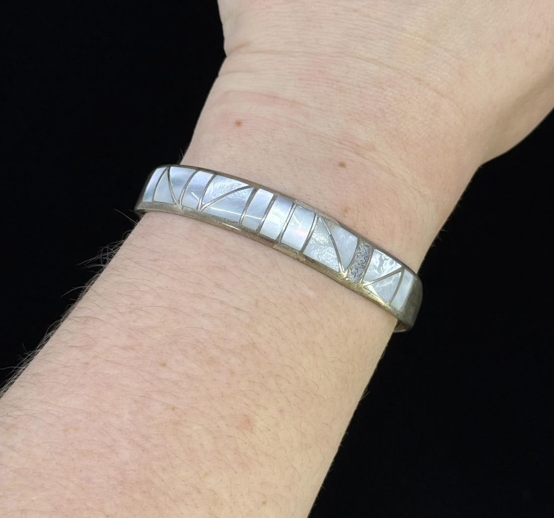 Zuni Sterling Mother of Pearl Bracelet: Stamped H/C as shown. 2 1/2" diameter. Weighs 15.26 grams. Missing a piece of inlay.