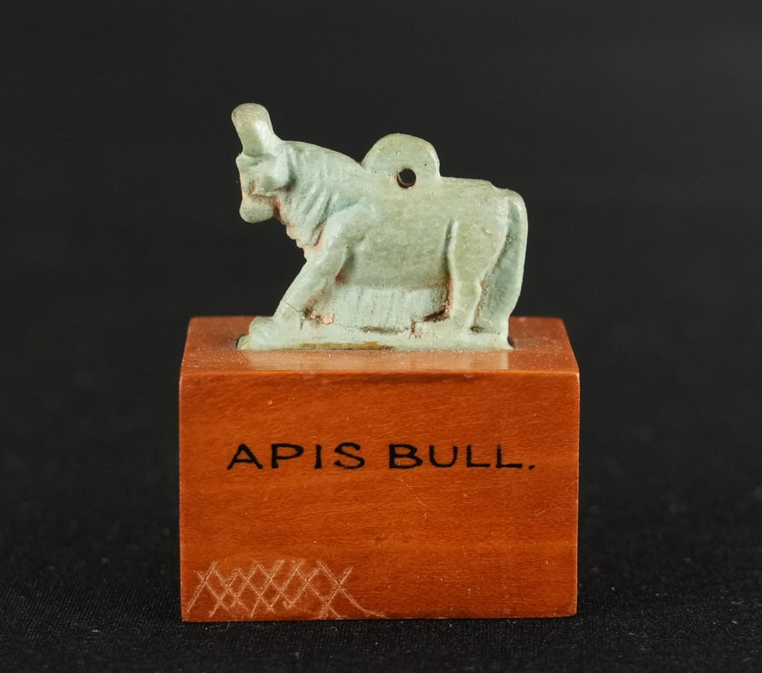 Ancient Egyptian Faience Apis Bull Amulet: 1 7/8" by 1 1/2" by 1". Late Period to Ptolemaic Period, 664-30 B.C. Apis represented fertility, strength, and a link between mortals and gods, particularly Ptah and Osiris. Provenance: From the estat