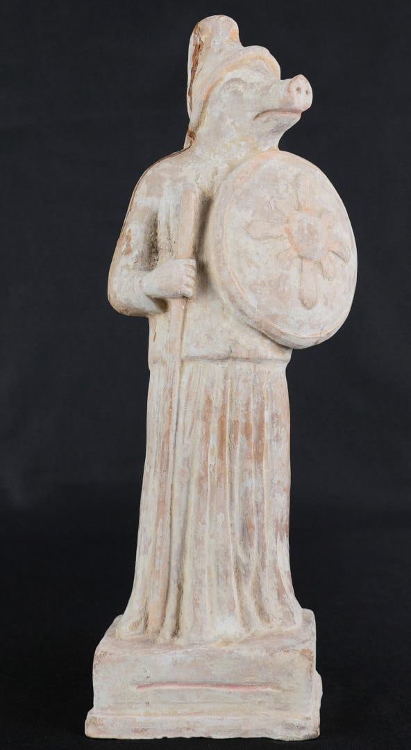 Ancient Trojan Terracotta Armed Pig Statue: Pig is sporting a Trojan Phrygian Cap. 11 1/2" by 4 1/2" by 3 1/4". Greco Roman, circa 8th century B.C.-2nd century A.D. Has been repaired as shown. Provenance: From the Iris Cornelia Love Collection