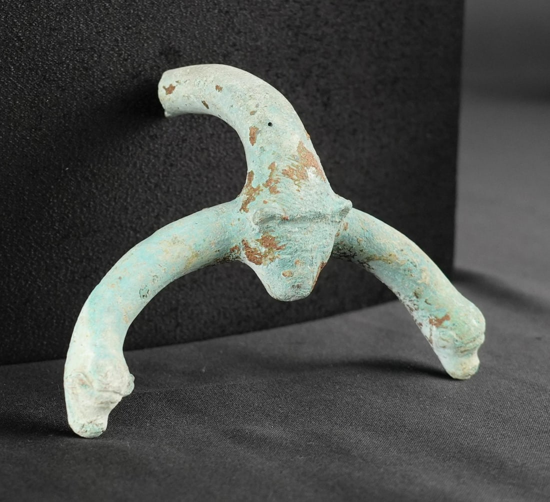 Ancient Laconian Bronze Oinochoe Handle Lion Heads: 3 1/2" by 3 1/2" by 1 1/4". Circa 6th Century B.C. Provenance: From the Iris Cornelia Love Collection (1933-2020), New York, primarily formed in the 1950s-1970s. Iris Cornelia Love (1933?2020) was an