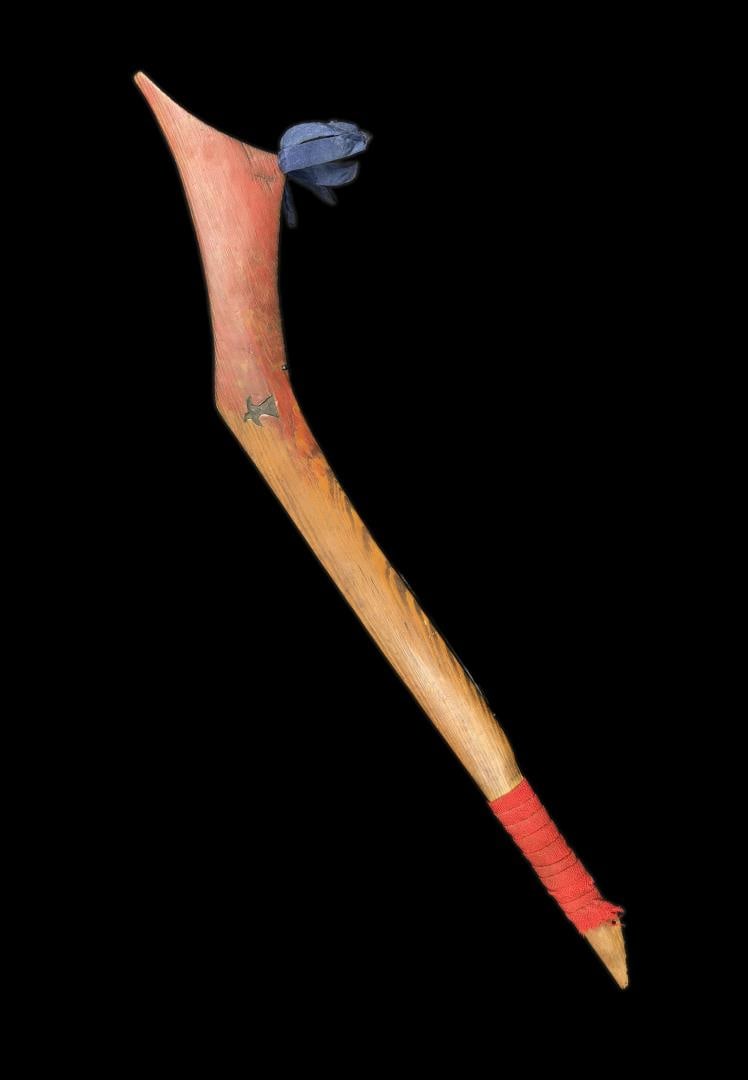 Sioux Native American Indian Gunstock War Club: Nice old red paint with Bird Carving, blue silk ribbon and red wood trade cloth. 26" long. Mid 19th Century. Provenance: Estate of Rodney Hilton Brown The War Museum