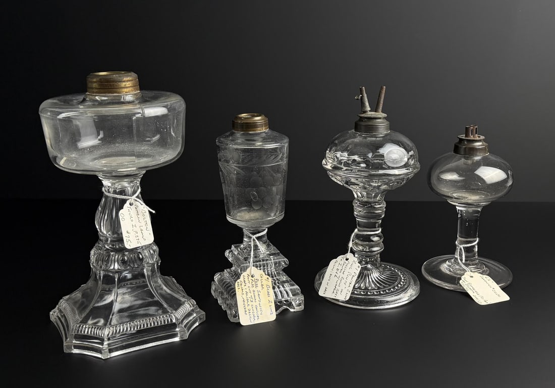 19th Century Pressed Glass Whale Oil Lamps: Largest is 9 1/2" tall. Far left is a Boston loop style with a pressed hexagon base, brass collar, and a heavy molded foot, 1860's. Second left has a pressed base with grape designs. Third is a