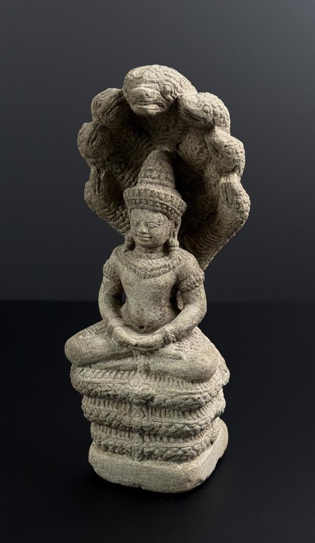 Khmer Sandstone Seven Naga Buddha: Sandstone Buddha on Muchalinda. A Khmer stone figure of Buddha seated in dhyana mudra on the three coiled body of the naga, its fragmentary seven heads rising behind the Lord Buddha's head forming a