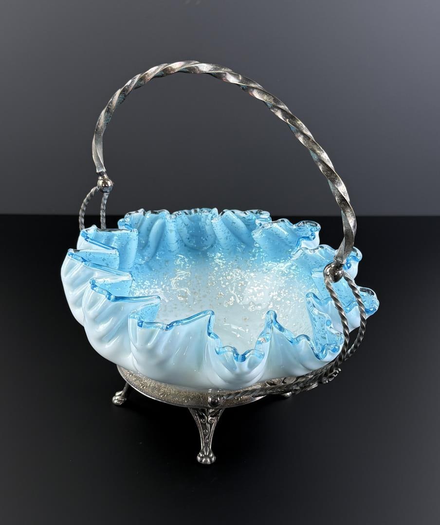 Spangle Glass Ruffled Brides Basket: 11 1/4" by 10 7/8" by 8 7/8". Brides basket with silver holder, white opal glass, silver plated frame marked W.M Rogers, with a twisted handle.