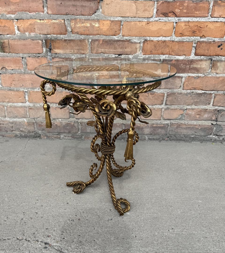 Italian Hollywood Recency Gold Gilt Side Table: 16" wide, 17 1/2" tall. Has rope tassel and floral details and a glass top.