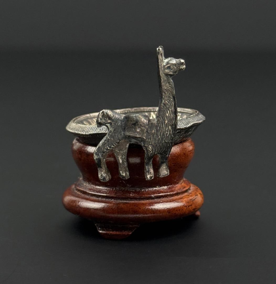 Sterling Silver Peruvian Coin Alpaca Dish: The Coin is .900 Silver and the Alpaca tests out to .925. 1 5/8" by 1 1/2" by 1 3/8". 42.79 grams total.