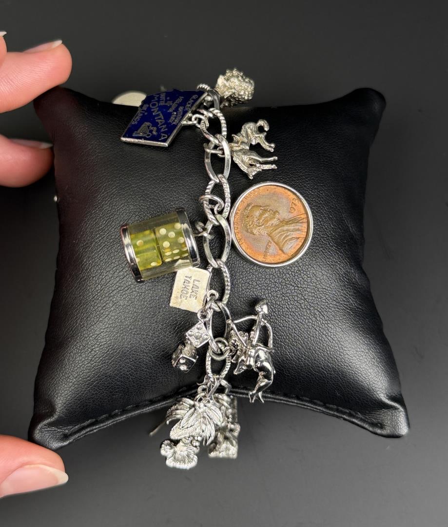 Sterling Silver Charm Bracelet: Total weight is 63.38 grams. NOT all charms are sterling. 8 7/8" long when laid flat.