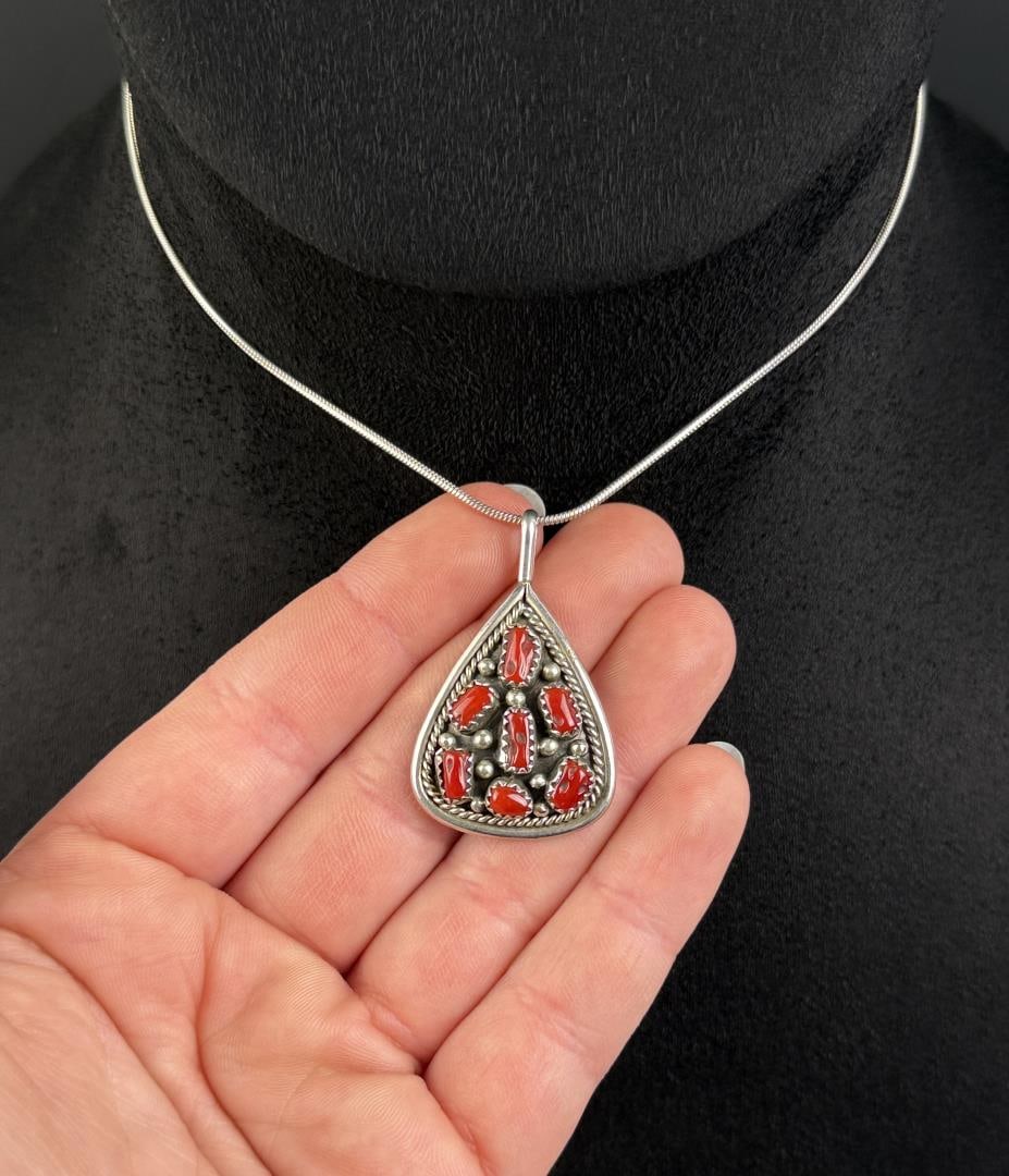 Navajo Irene Chiquito Sterling Coral Necklace: 12" long as displayed. 10.78 grams. Coral set in sterling silver teardrop shape pendant.