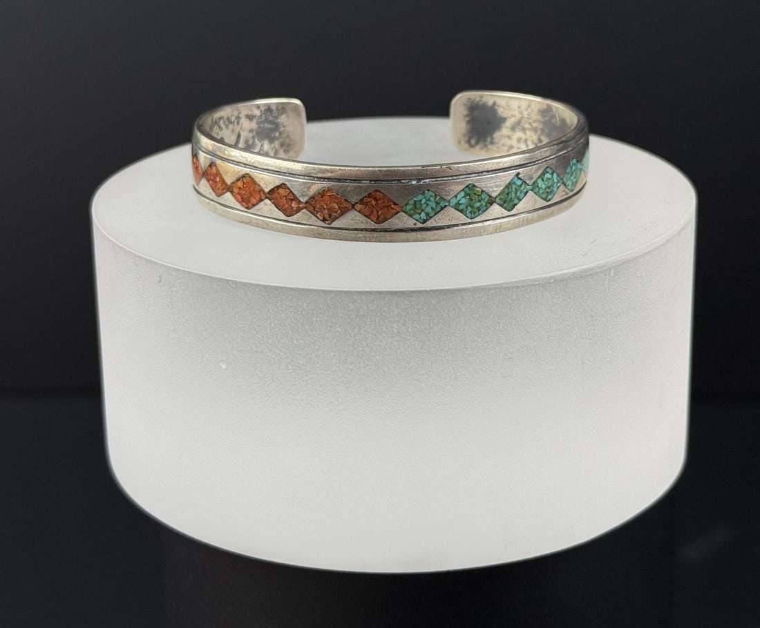 Thomas Singer Navajo Sterling Turquoise Bracelet: 5 1/2" internal circumference. 20.50 grams. Crushed turquoise and coral inlay.